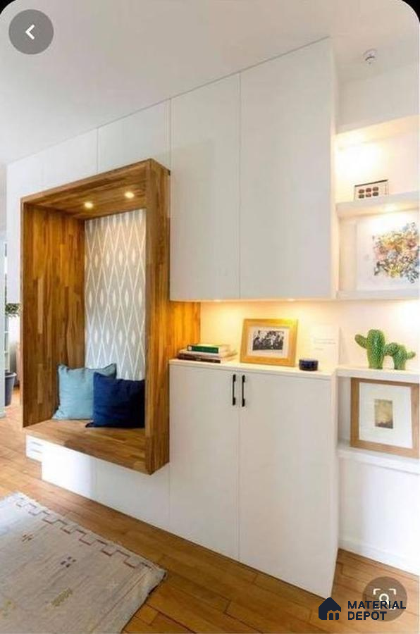 A kitchen with wooden cabinets and white counter tops, along with an island in the middle of the middle of the room with wood flooring and white counter top space to a kitchen filled with wooden cabinets and white